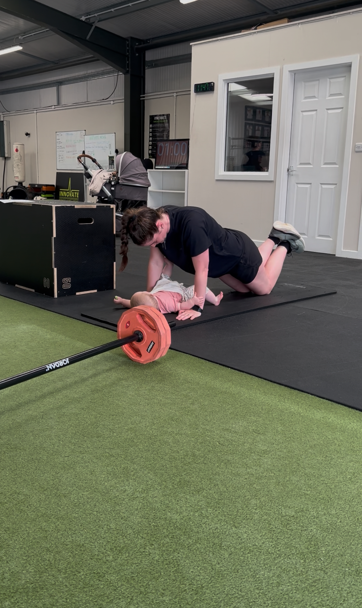Mum lifting a dumbbell with her baby in a pram